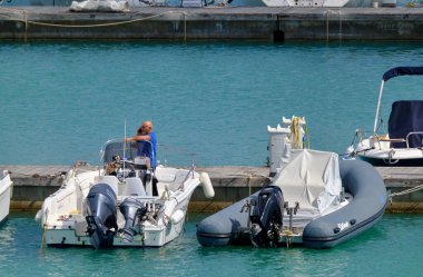 İtalya, Sicilya, Akdeniz, Marina di Ragusa (Ragusa Eyaleti); 21 Mayıs 2020, limandaki bir motorlu teknede adam - EDITORIAL