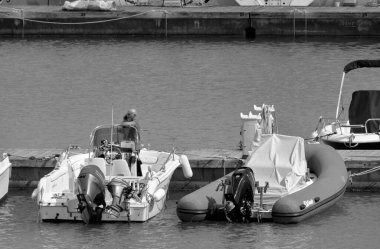 İtalya, Sicilya, Akdeniz, Marina di Ragusa (Ragusa Eyaleti); 21 Mayıs 2020, limandaki bir motorlu teknede adam - EDITORIAL