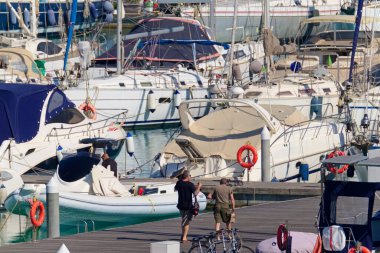 İtalya, Sicilya, Akdeniz, Marina di Ragusa (Ragusa Eyaleti); 22 Mayıs 2020, limandaki insanlar ve lüks yatlar - EDITORIAL