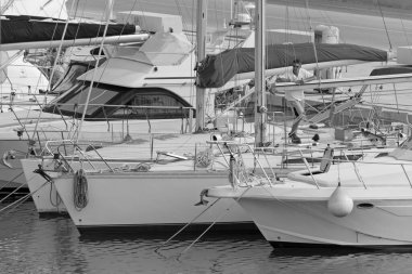 İtalya, Sicilya, Akdeniz, Marina di Ragusa (Ragusa Eyaleti); 26 Mayıs 2020, limandaki bir yelkenli teknesinde adam - EDITORIAL