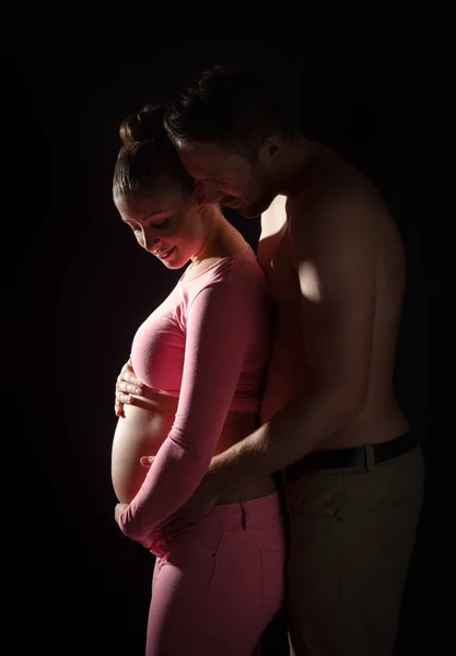 Schwangere junge Frau mit Mann im Studio — Stockfoto