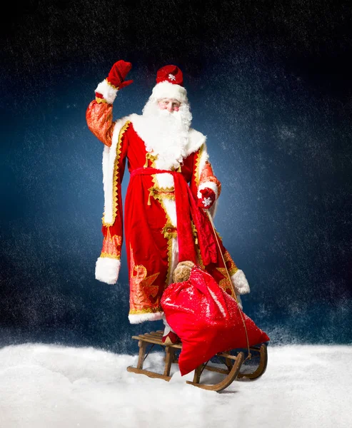 Санта летит на санях против снега — стоковое фото
