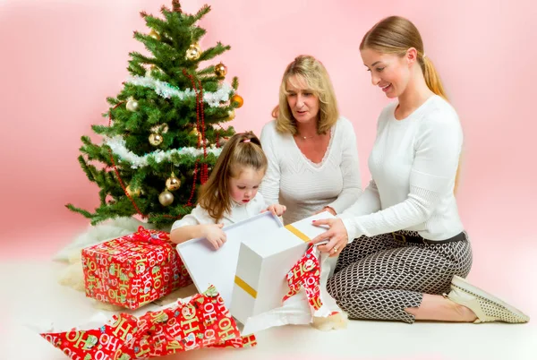 Abuela con hija adulta y nieto. bajo el árbol de navidad, abriendo regalos —  Fotos de Stock