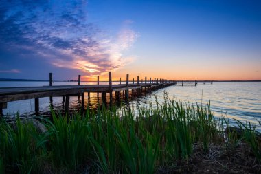 Sakin bir gölün üzerinde güzel, renkli bir gün batımı.