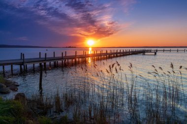 Sakin bir gölün üzerinde güzel romantik bir gün batımı
