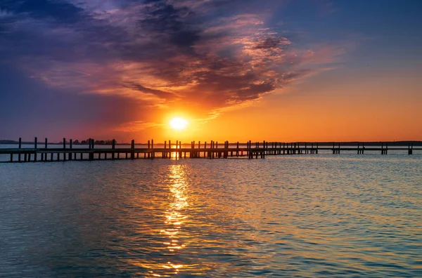Belo pôr do sol romântico sobre um lago calmo — Fotografia de Stock