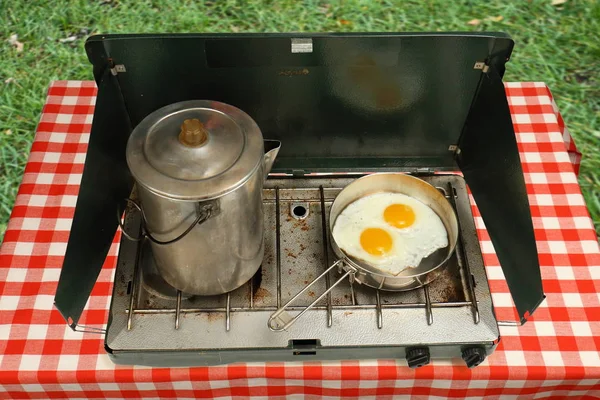Estufa de camping, huevos fritos y cafetera Fotos de stock