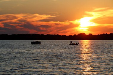 Pontoon ve balıkçı teknesi ile Washington Gölü üzerinde günbatımı