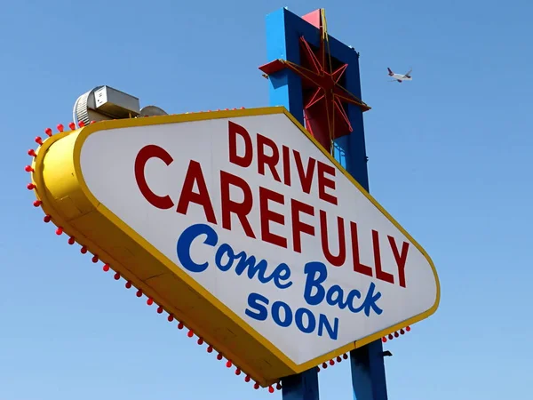 Drive Carefully, Come Back Soon Sign in Las Vegas with Departing Airplane — Stock Photo, Image