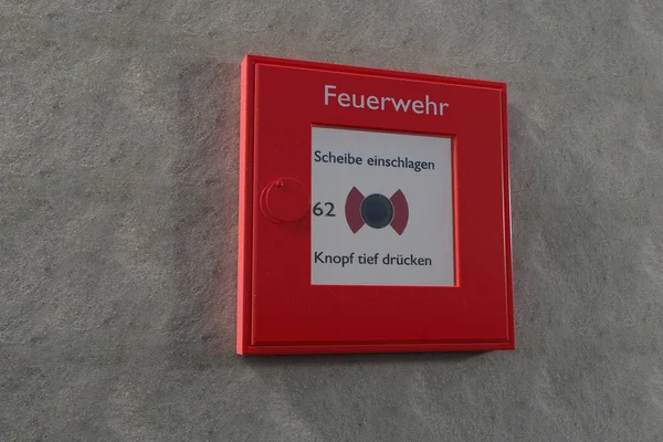 Caja de alarma de incendios alemana en una pared gris con espacio de copia Imagen de stock