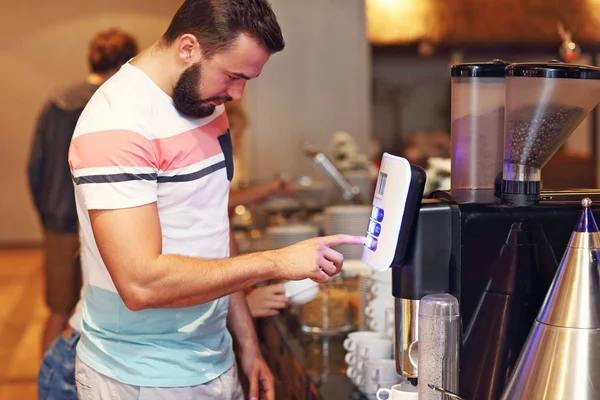 Attractive man using coffee machine — Stock Photo, Image