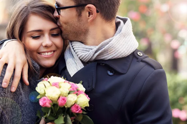 Casal jovem com flores — Fotografia de Stock