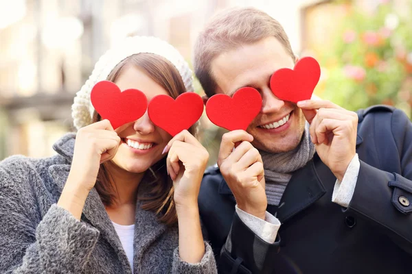 Happy couple covering eyes with hearts — Φωτογραφία Αρχείου