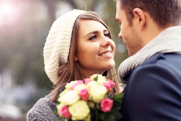 Casal feliz abraçando com flores — Fotografia de Stock