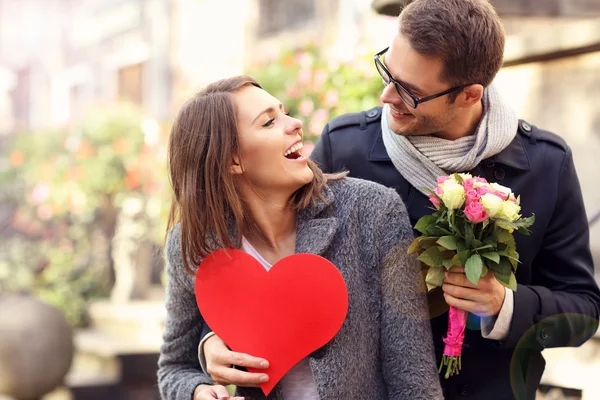 Hombre joven sorprendente mujer con flores — Foto de Stock