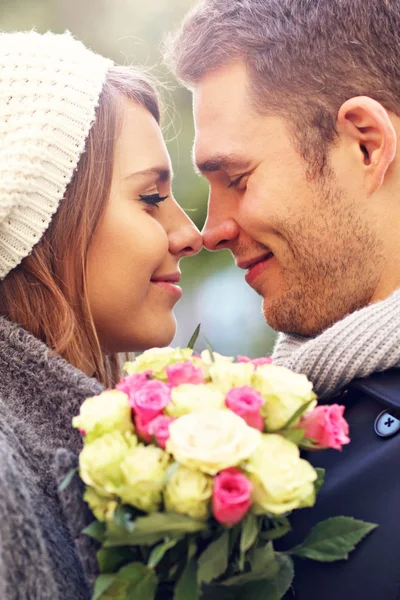 Casal jovem com flores — Fotografia de Stock