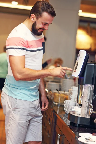 Aantrekkelijke man met behulp van koffiemachine — Stockfoto