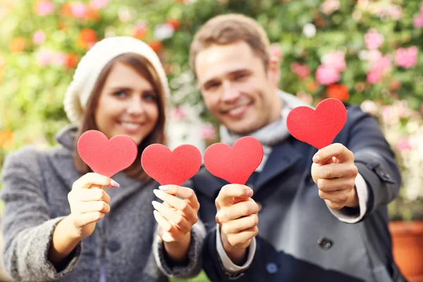 Couple heureux posant avec des cœurs — Photo