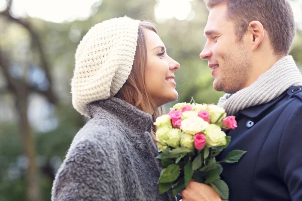 Pareja joven con flores — Foto de Stock