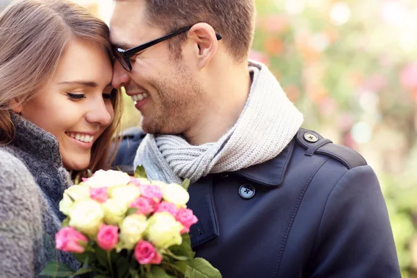 Жінка з квітами дарує обійми чоловікові — стокове фото