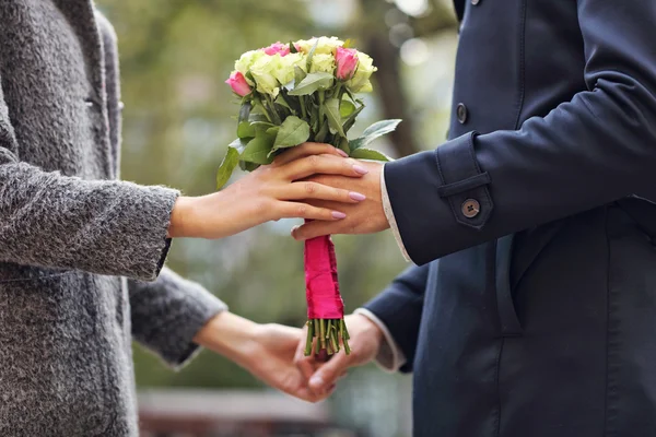 Pareja joven con flores — Foto de Stock