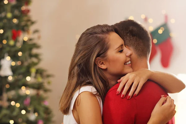 Casal abraçando árvore de Natal — Fotografia de Stock