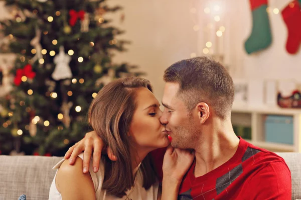 Пара целуется за елкой — стоковое фото