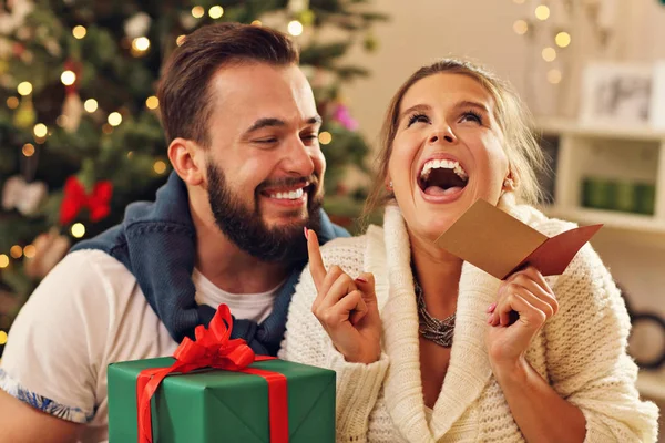 Casal com presente sobre a árvore de Natal — Fotografia de Stock