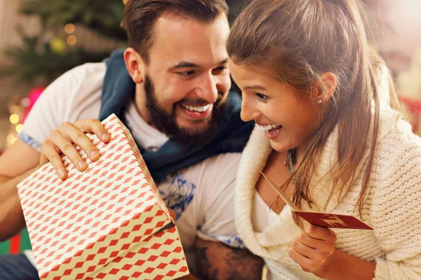 Pareja con regalo sobre árbol de Navidad —  Fotos de Stock