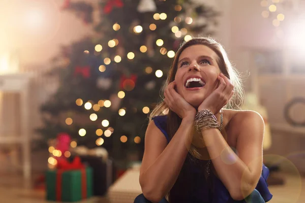 Woman sitting over Christmas tree — Stock Photo, Image