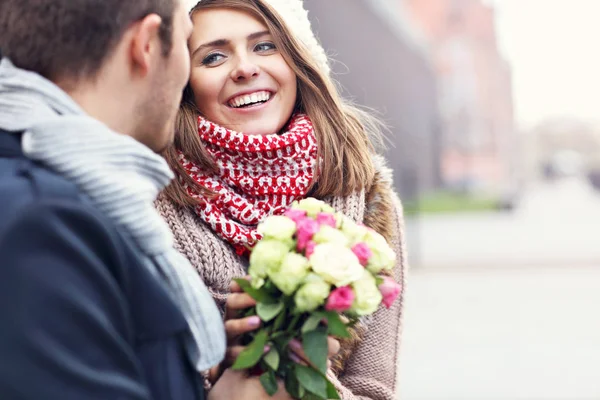 Молодая пара с цветами, встречающимися в городе — стоковое фото