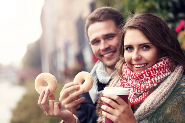 Pareja joven con rosquillas — Foto de Stock