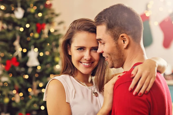 Pasangan berpelukan di atas pohon Natal — Stok Foto