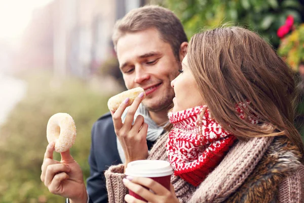 Pareja joven con rosquillas — Foto de Stock