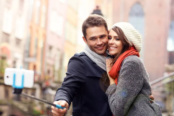 Pareja joven tomando fotos con palo sefie — Foto de Stock