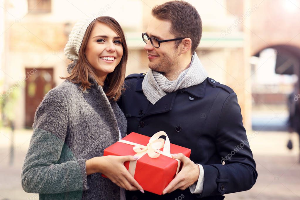 Young couple with big present in the city