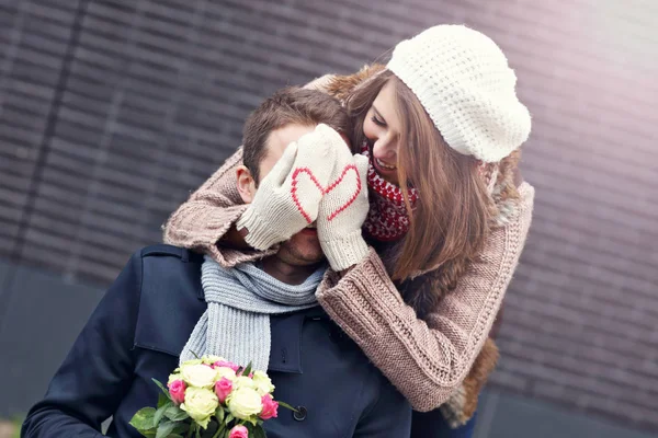 Mladý pár s květinami randění ve městě — Stock fotografie