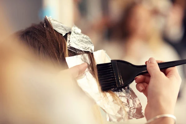 Парикмахер раскрашивает волосы в студии — стоковое фото
