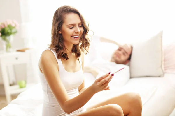 Woman with pregnancy test in bedroom — Stock Photo, Image