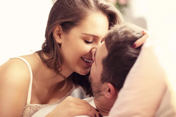 Junges Paar küsst sich im Bett — Stockfoto