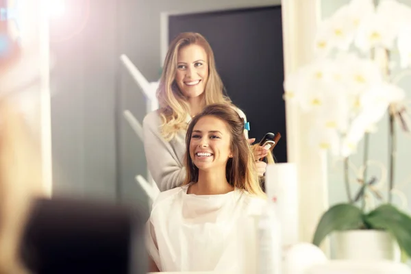 Hairdresser using hair straightener — Stock Photo, Image