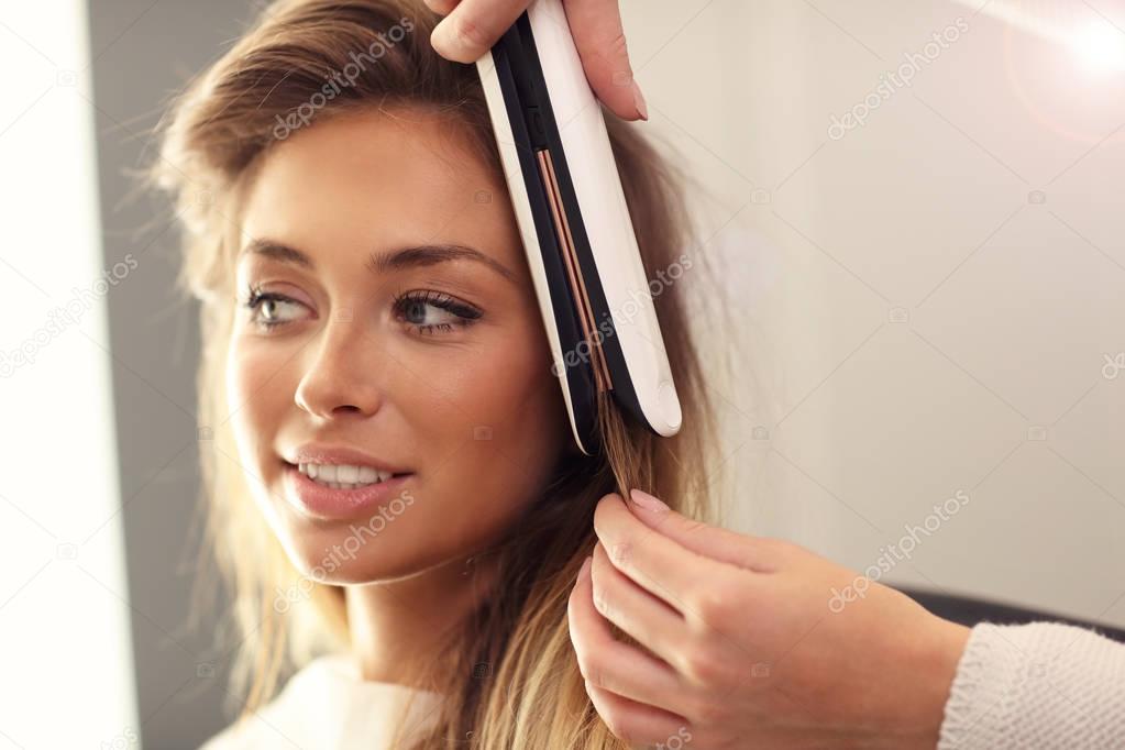 Hairdresser using hair straightener