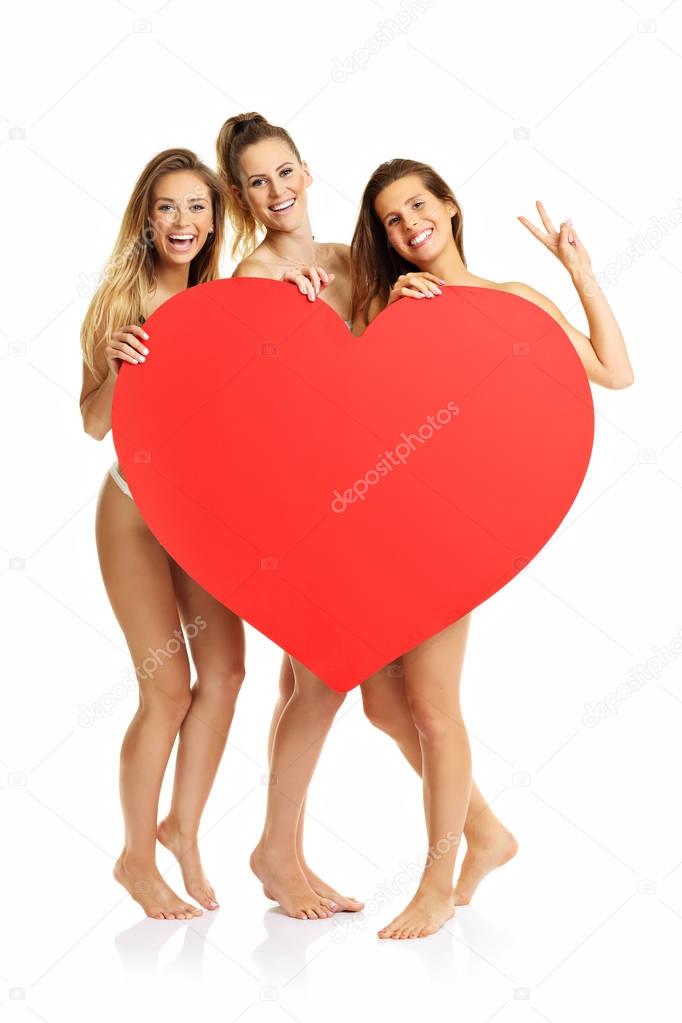 Group of happy friends posing with heart