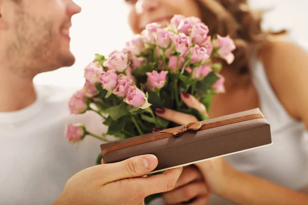 Homem dando flores e presente para a mulher — Fotografia de Stock