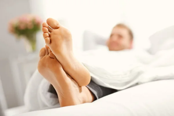 Hombre feliz descansando en el dormitorio — Foto de Stock