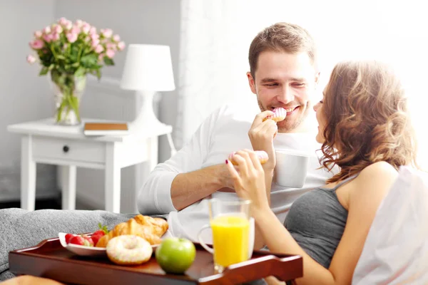 Giovane coppia che fa colazione a letto — Foto Stock