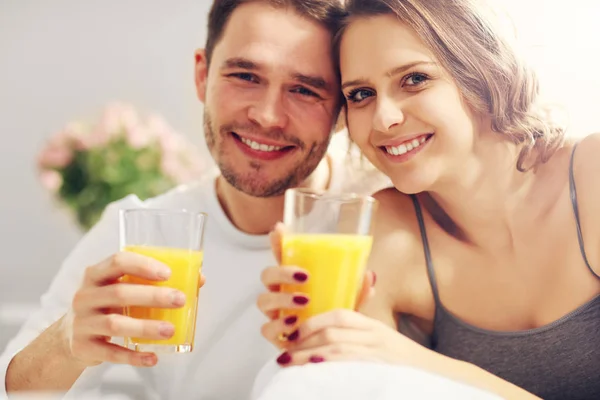 Pareja joven desayunando en la cama — Foto de Stock