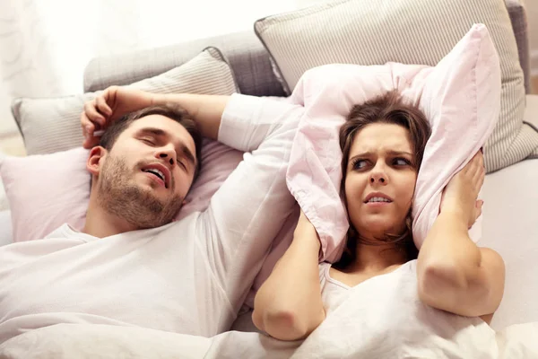いびきをかく男とベッドで怒っている女性 — ストック写真
