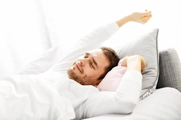 Bonito homem se alongando na cama — Fotografia de Stock