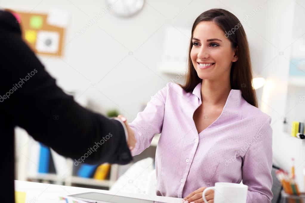 Businesswoman shaking hands in office